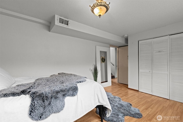 1350 S Woodlawn St, Tacoma, WA 98465 - bedroom with wood finished floors, a textured ceiling, and a closet