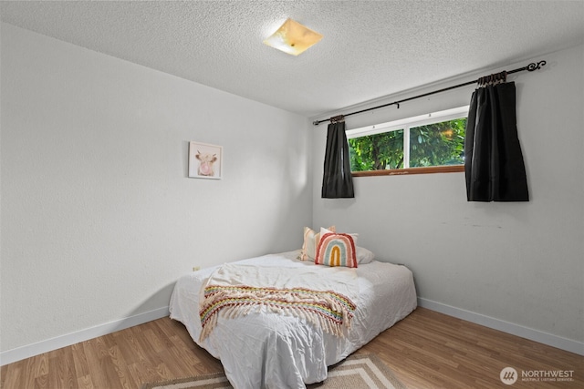 1350 S Woodlawn St, Tacoma, WA 98465 - bedroom with wood finished floors and a textured ceiling
