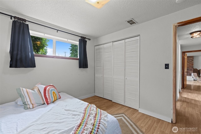 1350 S Woodlawn St, Tacoma, WA 98465 - bedroom featuring a textured ceiling, a closet, and wood finished floors