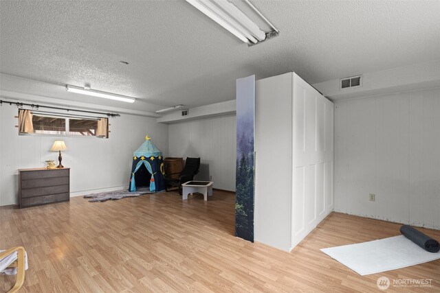 1350 S Woodlawn St, Tacoma, WA 98465 - below grade area with a textured ceiling and light wood finished floors