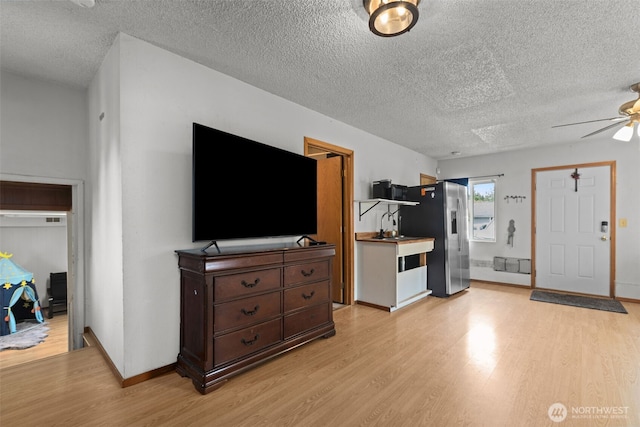 1350 S Woodlawn St, Tacoma, WA 98465 - living room featuring light wood-style flooring, a ceiling fan, and a textured ceiling