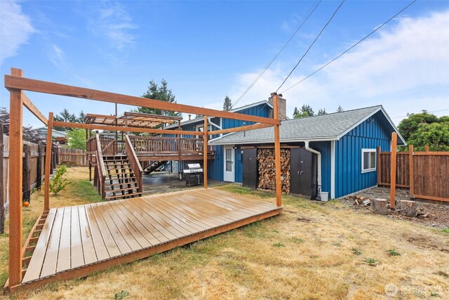 1350 S Woodlawn St, Tacoma, WA 98465 - back of property with board and batten siding, a wooden deck, a fenced backyard, and stairway