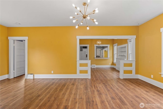 506 Douglas St, Wenatchee, WA 98801 - unfurnished living room featuring a chandelier, wood finished floors, and baseboards