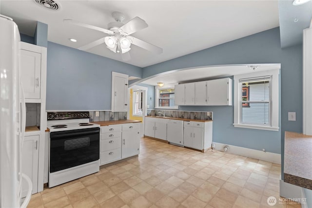506 Douglas St, Wenatchee, WA 98801 - kitchen featuring white appliances, arched walkways, white cabinets, ceiling fan, and a sink