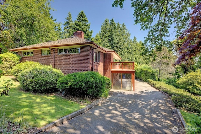 17004 16th Ave SW, Normandy Park, WA 98166 - view of property exterior with a chimney, brick siding, a deck, and a lawn