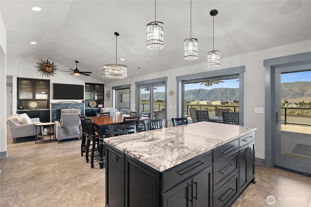 111 Wren Loop SW, Mattawa, WA 99349 - kitchen featuring vaulted ceiling, a ceiling fan, pendant lighting, light stone countertops, and a center island