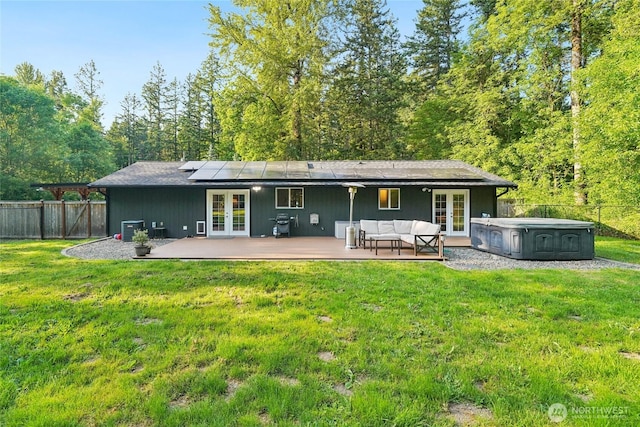 11924 210th St E, Graham, WA 98338 - back of property featuring french doors, a hot tub, central AC, roof mounted solar panels, and a deck