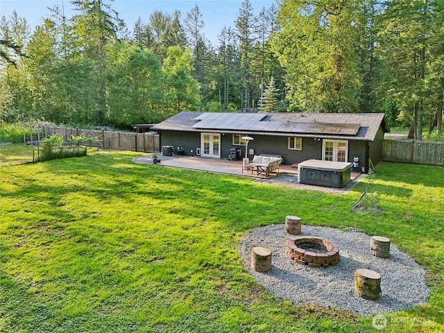 11924 210th St E, Graham, WA 98338 - back of property featuring french doors, an outdoor fire pit, a hot tub, and a patio area