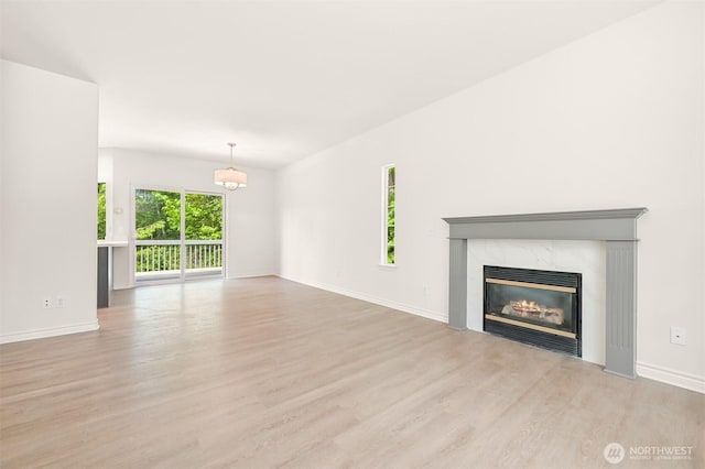 1999 Governor Rd, Bellingham, WA 98229 - unfurnished living room with wood finished floors, a premium fireplace, and a chandelier