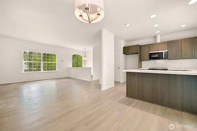 1999 Governor Rd, Bellingham, WA 98229 - kitchen with stainless steel microwave, light wood-type flooring, light countertops, decorative backsplash, and recessed lighting
