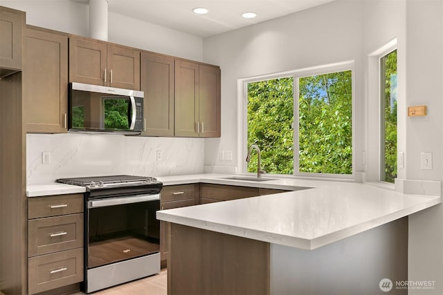1999 Governor Rd, Bellingham, WA 98229 - kitchen featuring stainless steel appliances, a peninsula, light countertops, decorative backsplash, and recessed lighting
