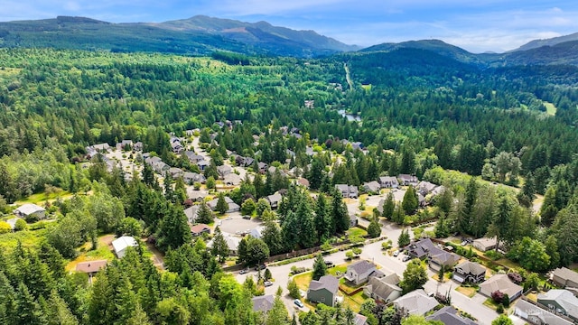 1999 Governor Rd, Bellingham, WA 98229 - aerial perspective of suburban area with a heavily wooded area and a mountain backdrop