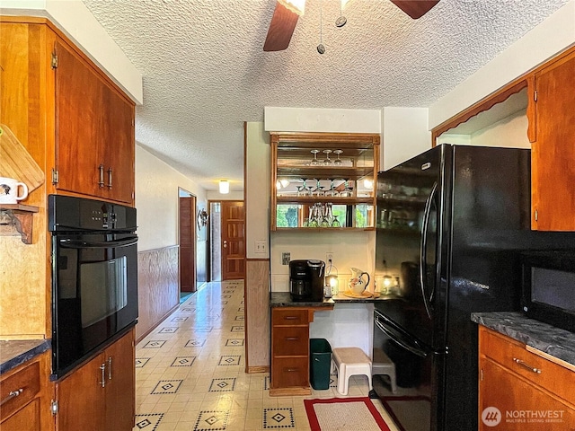 2208 Sandra Ave, Centralia, WA 98531 - kitchen with black appliances, a ceiling fan, a textured ceiling, dark countertops, and wainscoting