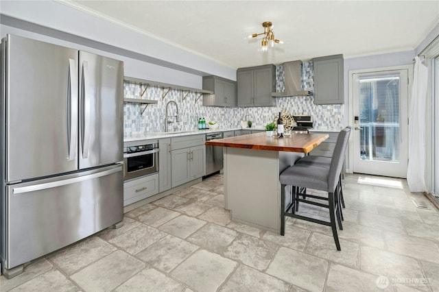 13712 SE 44th St, Bellevue, WA 98006 - kitchen with appliances with stainless steel finishes, wood counters, wall chimney exhaust hood, gray cabinetry, and a sink