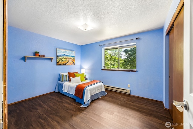10320 46th Ave SE, Olympia, WA 98513 - bedroom with baseboard heating, wood finished floors, a closet, and a textured ceiling