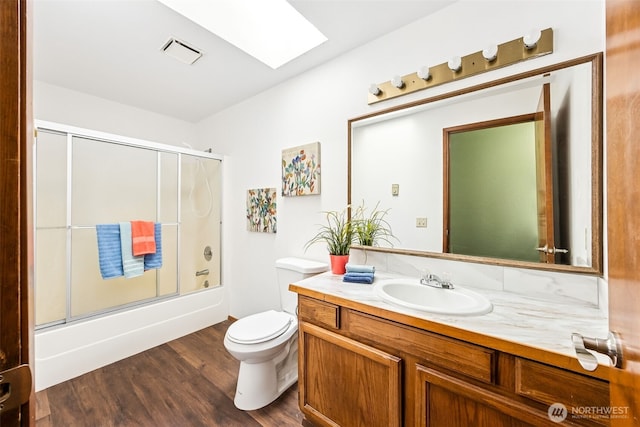 10320 46th Ave SE, Olympia, WA 98513 - bathroom featuring a skylight, vanity, wood finished floors, and combined bath / shower with glass door