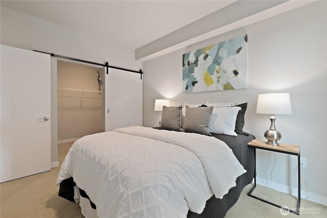 1085 103rd Ave NE Unit 203, Bellevue, WA 98004 - bedroom featuring carpet floors, a barn door, baseboards, a walk in closet, and a closet