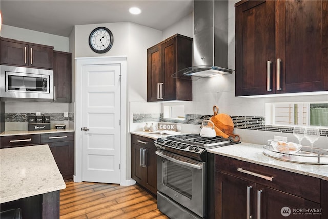 35681 30th Ave S, Federal Way, WA 98003 - kitchen featuring stainless steel appliances, wall chimney range hood, light wood-type flooring, backsplash, and light stone countertops