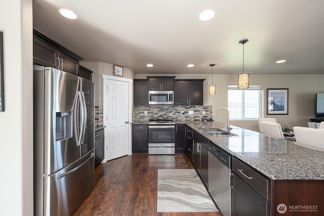 1300 W Marina Dr Unit 1, Moses Lake, WA 98837 - kitchen featuring appliances with stainless steel finishes, a sink, a peninsula, light stone counters, and dark wood-style flooring