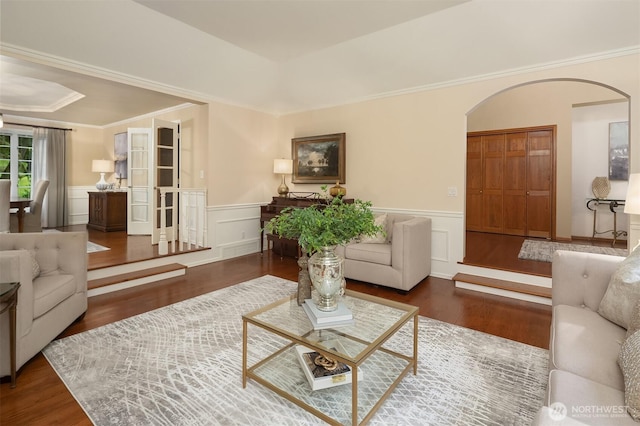2805 Sahalee Dr E, Sammamish, WA 98074 - living room featuring arched walkways, wood finished floors, wainscoting, a decorative wall, and crown molding
