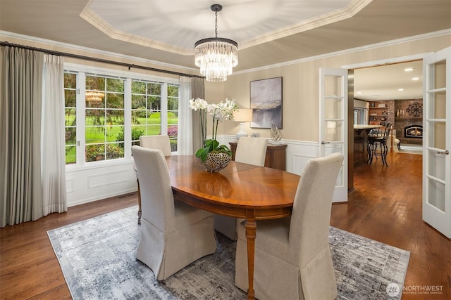 2805 Sahalee Dr E, Sammamish, WA 98074 - dining room featuring crown molding, a chandelier, wood finished floors, a decorative wall, and a raised ceiling