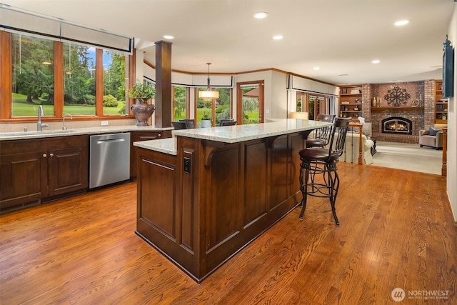 2805 Sahalee Dr E, Sammamish, WA 98074 - kitchen with stainless steel dishwasher, light stone counters, wood finished floors, a kitchen breakfast bar, and open floor plan
