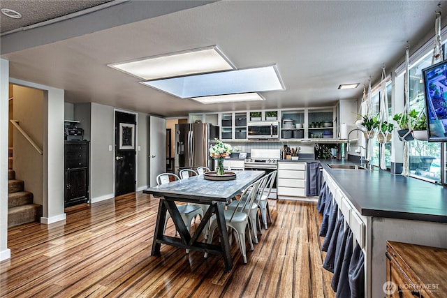 5613 89th Ave W, University Place, WA 98467 - kitchen featuring stainless steel appliances, a sink, dark countertops, wood finished floors, and open shelves
