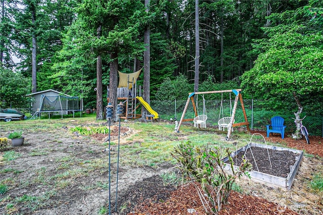 5613 89th Ave W, University Place, WA 98467 - view of yard featuring a trampoline, a playground, and a vegetable garden