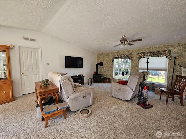 1089 Monte Elma Rd, Elma, WA 98541 - living room featuring ceiling fan, lofted ceiling, a wood stove, a textured ceiling, and carpet
