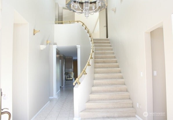 8122 Coquitlam Pl, Blaine, WA 98230 - stairway with a chandelier, tile patterned floors, and baseboards
