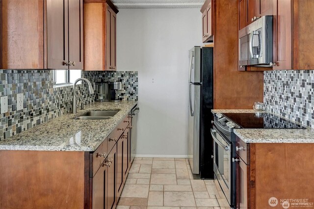 4561 Lake Washington Blvd NE Unit 303, Kirkland, WA 98033 - kitchen with stainless steel appliances, a sink, baseboards, backsplash, and light stone countertops
