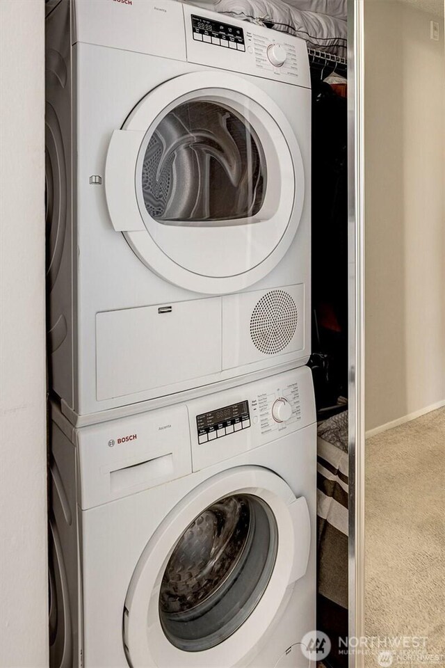 4561 Lake Washington Blvd NE Unit 303, Kirkland, WA 98033 - laundry room featuring stacked washer and clothes dryer, carpet floors, and baseboards
