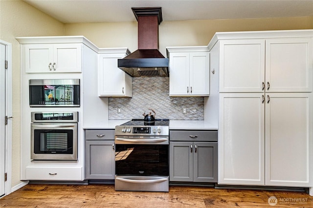 300 Fircrest Dr, Sequim, WA 98382 - kitchen with stainless steel appliances, gray cabinets, wall chimney exhaust hood, decorative backsplash, and light countertops