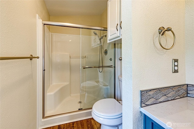 300 Fircrest Dr, Sequim, WA 98382 - bathroom featuring a textured wall, toilet, a shower stall, and wood finished floors