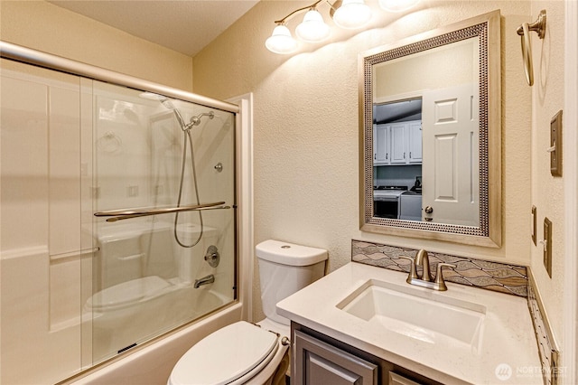 300 Fircrest Dr, Sequim, WA 98382 - bathroom with a textured wall, toilet, vanity, shower / bath combination with glass door, and washer and dryer