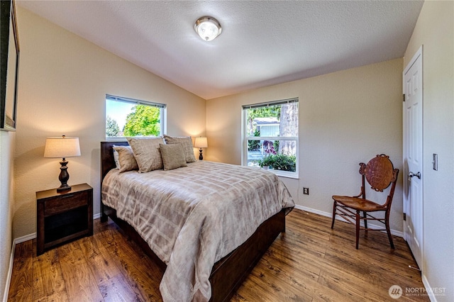 300 Fircrest Dr, Sequim, WA 98382 - bedroom featuring lofted ceiling, wood finished floors, baseboards, and a textured ceiling