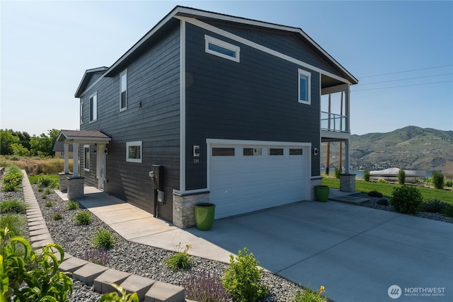 200 Pinnacle Pl, Chelan, WA 98816 - view of side of property with an attached garage, a balcony, a mountain view, and driveway