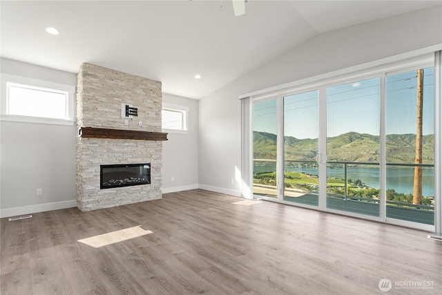 200 Pinnacle Pl, Chelan, WA 98816 - unfurnished living room with lofted ceiling, a fireplace, baseboards, wood finished floors, and a water and mountain view