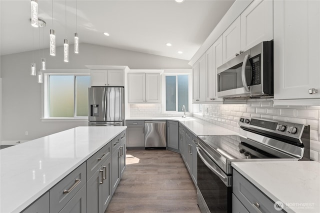 200 Pinnacle Pl, Chelan, WA 98816 - kitchen featuring stainless steel appliances, gray cabinets, vaulted ceiling, backsplash, and pendant lighting