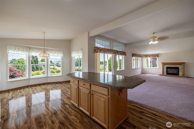580 Canyon Dr, East Wenatchee, WA 98802 - kitchen featuring a ceiling fan, dark countertops, dark wood finished floors, a glass covered fireplace, and a center island