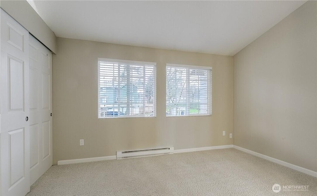 13145 102nd Ln NE Unit 5, Kirkland, WA 98034 - unfurnished bedroom with a baseboard heating unit, carpet floors, baseboards, and a closet