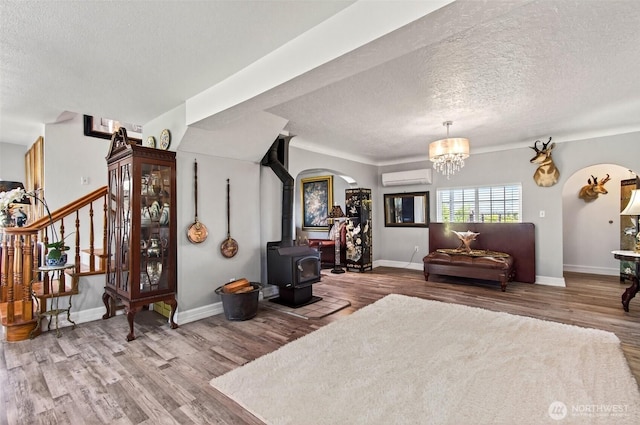 10 E Sunny Sands Rd, Cathlamet, WA 98612 - living room featuring a wall mounted AC, a textured ceiling, wood finished floors, and baseboards