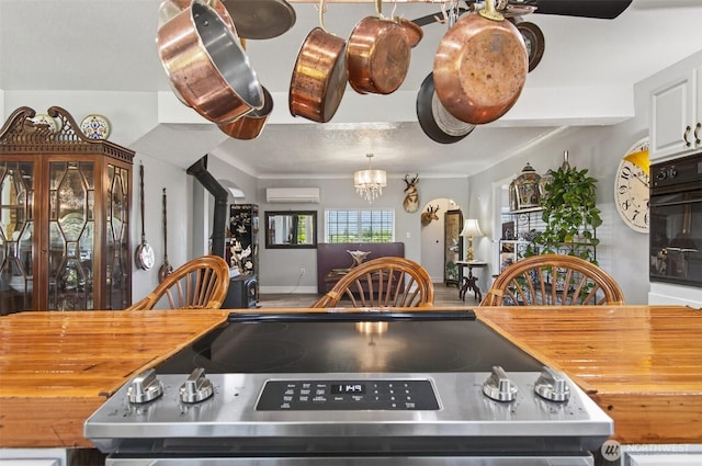 10 E Sunny Sands Rd, Cathlamet, WA 98612 - kitchen featuring wood counters, electric range, a wall mounted air conditioner, black oven, and a wood stove