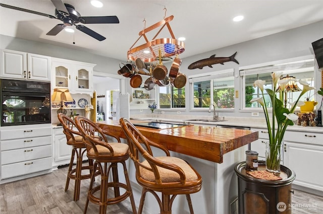 10 E Sunny Sands Rd, Cathlamet, WA 98612 - kitchen with black appliances, wooden counters, white cabinetry, recessed lighting, and light wood-style floors