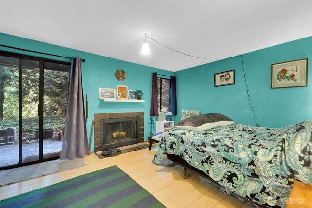 15370 62nd Ave S Unit B4, Tukwila, WA 98118 - bedroom featuring access to exterior, wood finished floors, and a fireplace with flush hearth