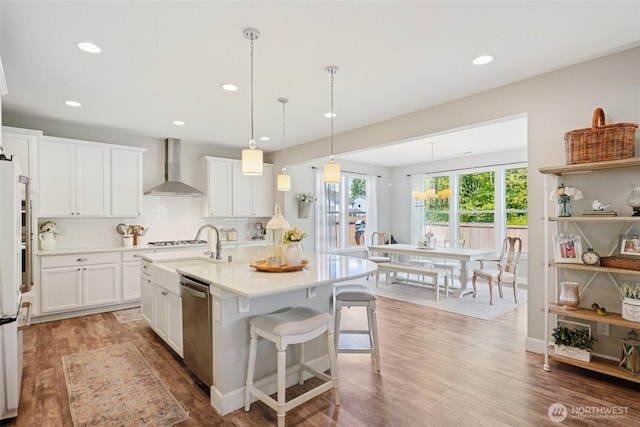 648 S Davis St, Buckley, WA 98321 - kitchen with wall chimney range hood, stainless steel dishwasher, light countertops, light wood finished floors, and recessed lighting