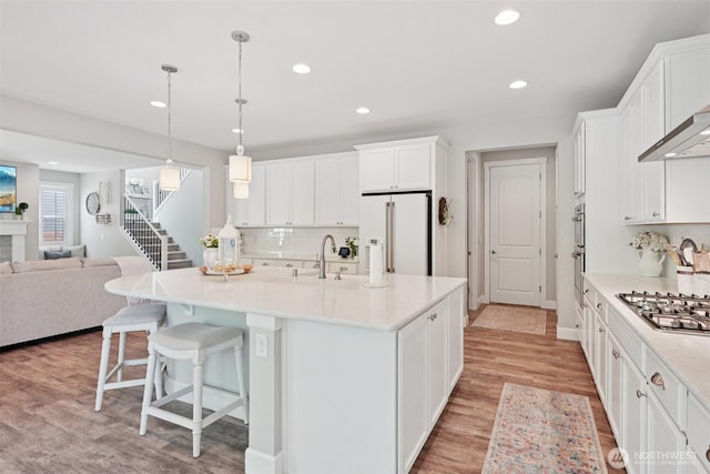 648 S Davis St, Buckley, WA 98321 - kitchen featuring high quality fridge, stainless steel gas cooktop, open floor plan, recessed lighting, and white cabinetry