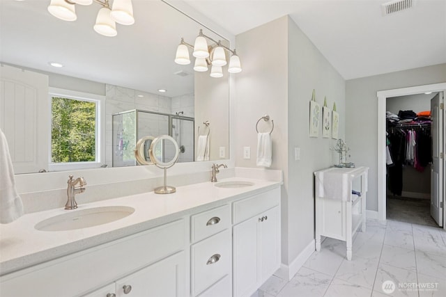 648 S Davis St, Buckley, WA 98321 - full bath featuring baseboards, a stall shower, marble look tiles, double vanity, and a walk in closet