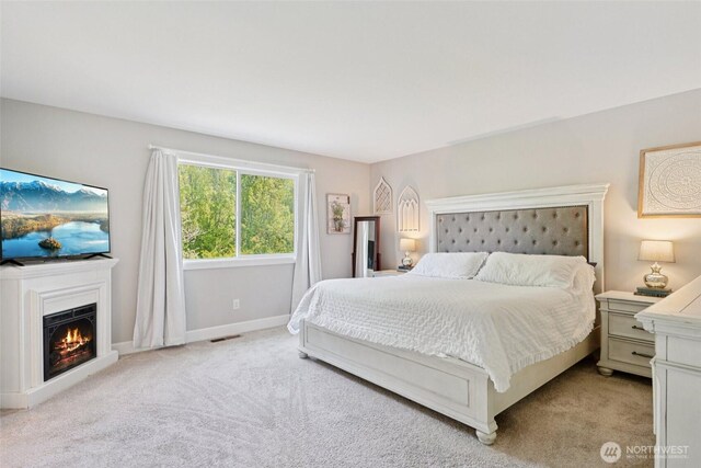 648 S Davis St, Buckley, WA 98321 - bedroom featuring light colored carpet, a warm lit fireplace, and baseboards