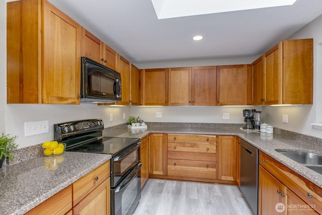 1728 106th St SW, Everett, WA 98204 - kitchen with black appliances, a skylight, light wood-style floors, recessed lighting, and stone countertops